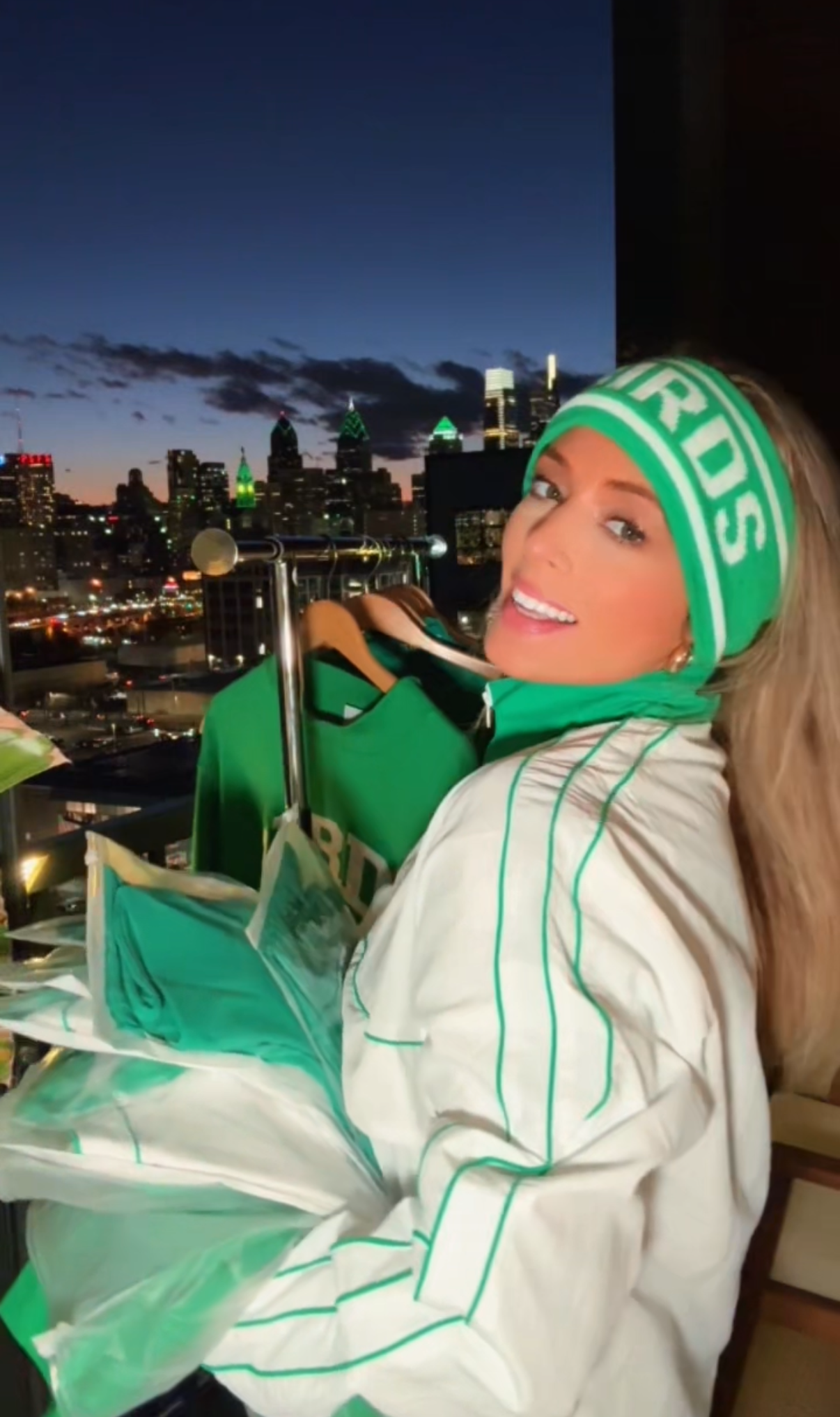 South & Green co-founder Brooke wearing South & Green's BIRDS Ski Headband and BIRDS Windbreaker with a Philadelphia skyline in the background.