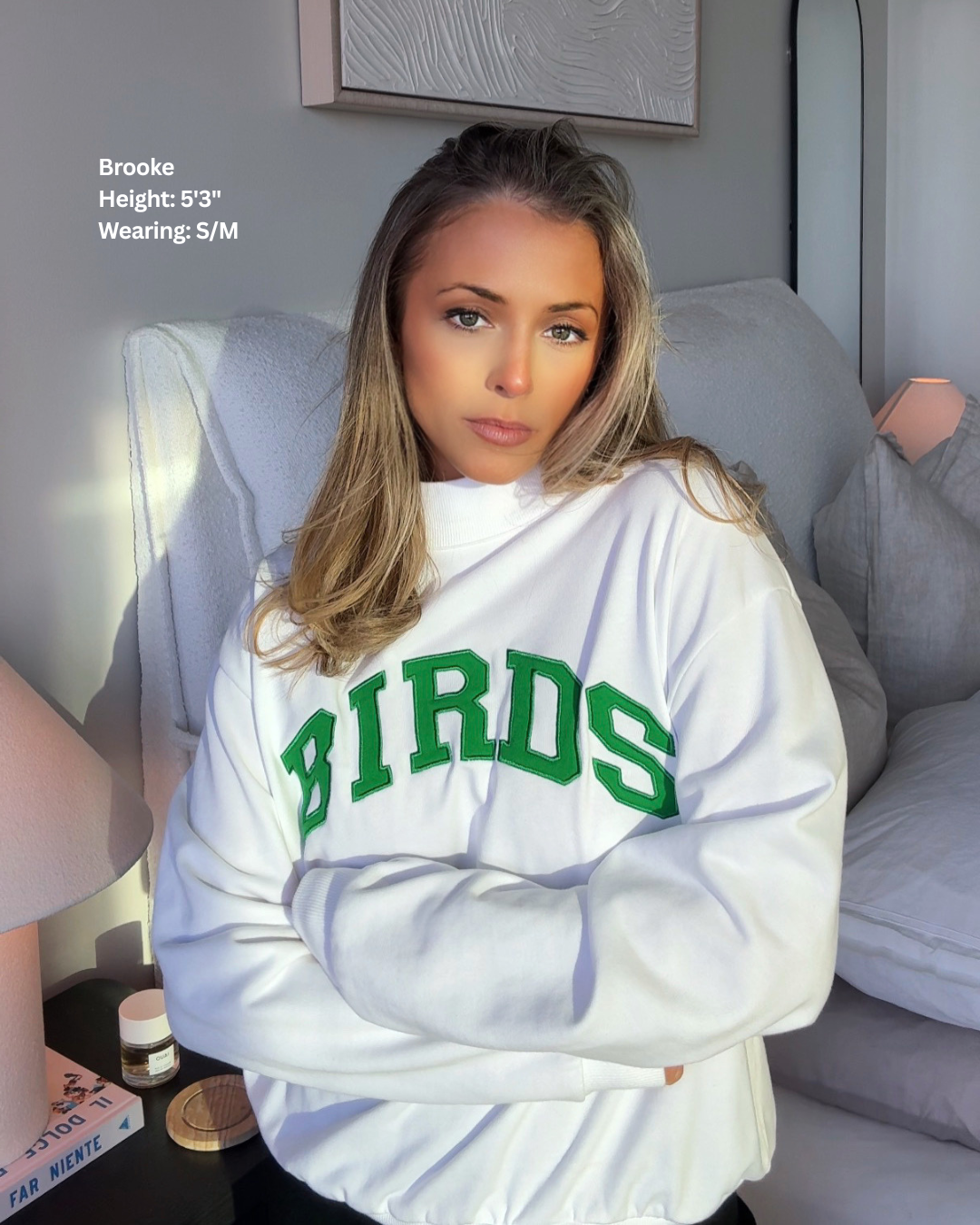 South & Green co-founder, Brooke, wearing South & Green's White BIRDS Varsity Mockneck in size S/M. 