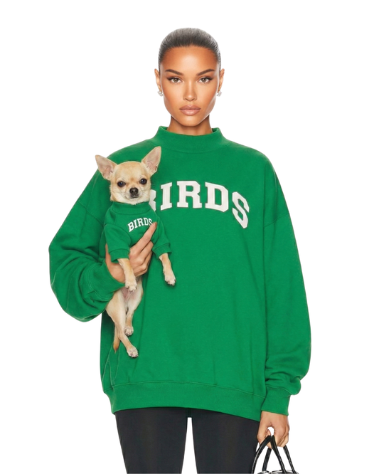 Model wearing an oversized fit of South & Green's BIRDS Varsity Mockneck in Kelly Green while holding her Chihuahua who is wearing South & Green's BIRDS Varsity Barkneck in Kelly Green.